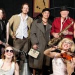 A diverse group of musicians with various instruments on stage.