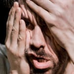 close up of a performers face as they contort their features with both hands James Thierrée performance Raoul